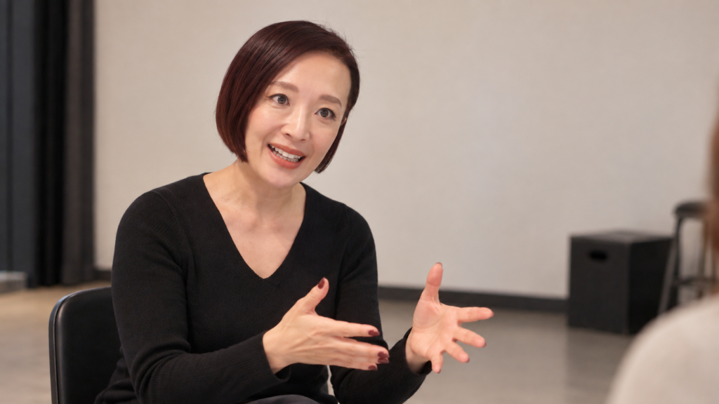 演技コーチが稽古場で俳優指導について説明している様子