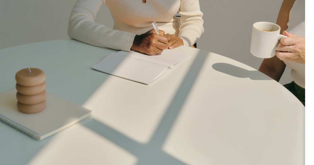 机でノートに書き込みをしながら準備する人の手元