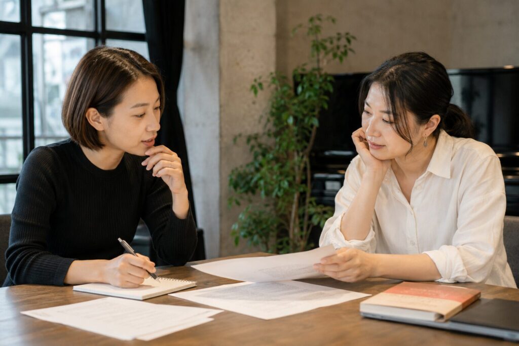 台本や資料を見ながら演技の課題について話し合う日本人女性二人